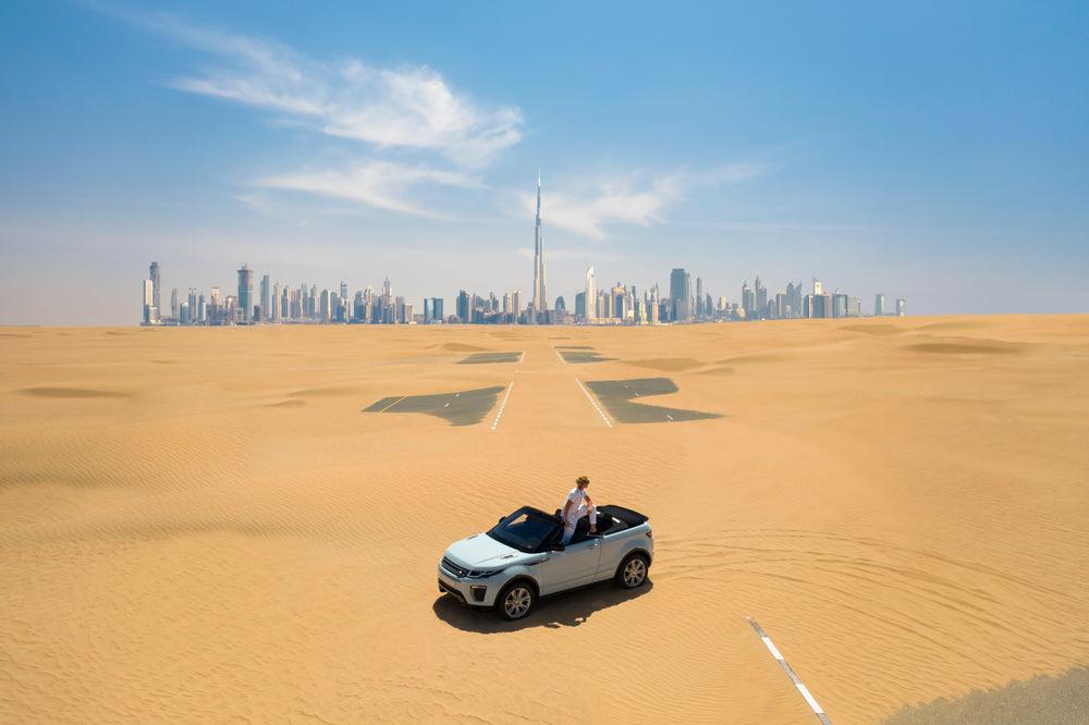 car on a desert road in Dubai